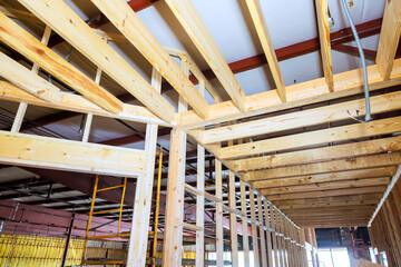 Wooden beams rafters in construction space as work continues on renovation project.