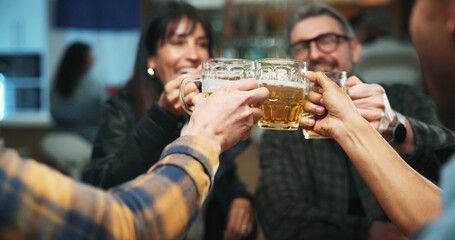 Friends, hands and toast beer at bar, celebration and excited for party, happy hour and drinks. People, glasses and cheers at pub with alcohol, success or milestone with congratulations at night