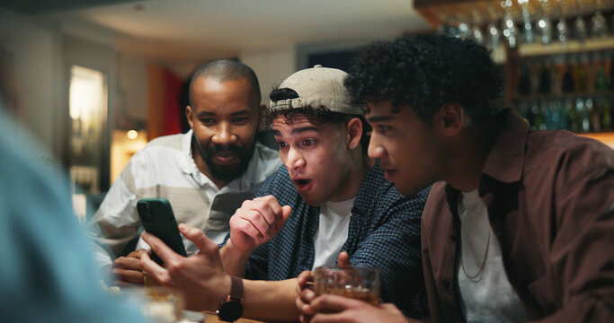 Surprise, friends and watching tv with phone in pub for sports match, score lead or social gathering. Football fans, people and smartphone with suspense in bar for streaming game, event and bonding - Powered by Adobe