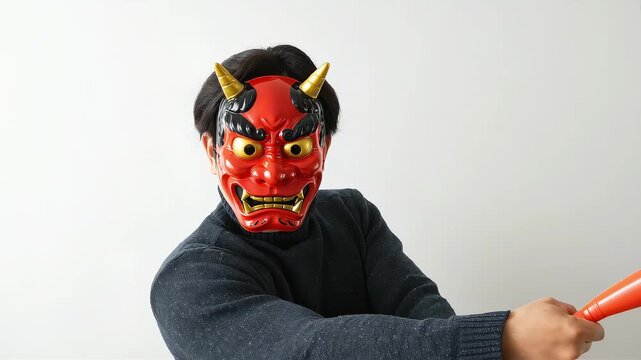 節分で、赤鬼の面をかぶり金棒をバットのように振る男性