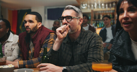 Obraz premium Stress, watching tv and friends in pub for sports game with championship for entertainment together. Anxiety, live streaming and group of male fans with football match in bar for online tournament.