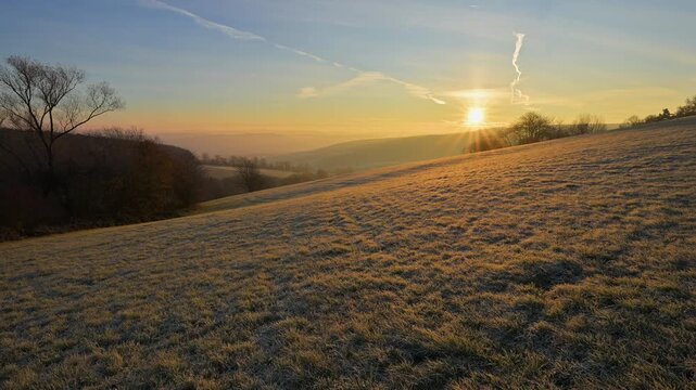 Ein frostiger Morgen mit Sonnenaufgang &uuml;ber einer sanften H&uuml;gellandschaft, Seckmauern, L&uuml;tzelbach, Maintal, Odenwald, Hessen, Deutschland
