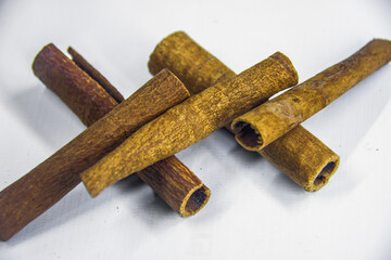 Brown dry raw organic cinnamon roll, spices ingredient, decoration graphic design, closeup food studio shot, isolated on white background, selective focus, shallow depth of field, taken at Cairo Egypt