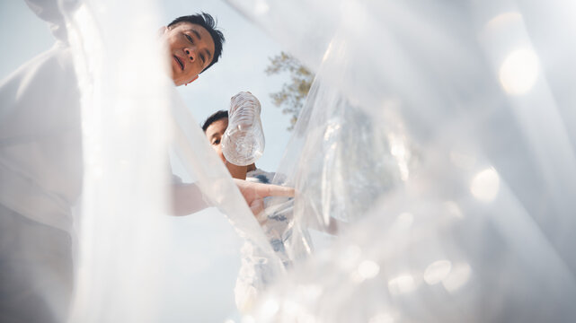 family, conservation, environmental, clean, beach, holiday, asian, fun, A family collects plastic waste during a beach cleanup, teaching responsibility and environmental care.