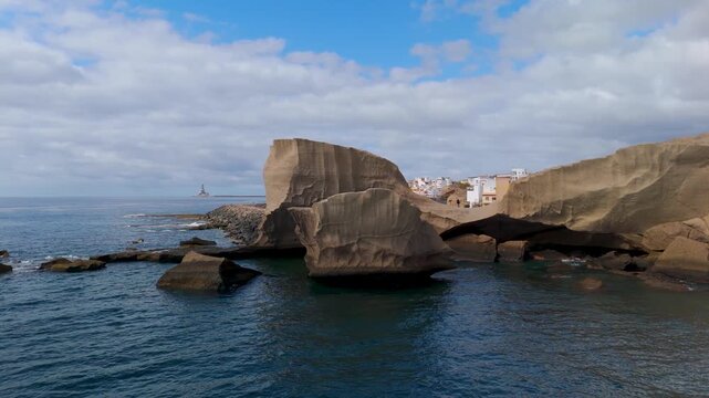 Drone circling shot of the iconic volcanic islets and fishing boats near the harbor of San Miguel de Tajao, Arico, Tenerife, Canary Islands.