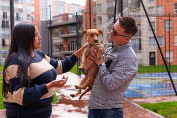 Couple discussing puppy adoption and pet ownership in urban park