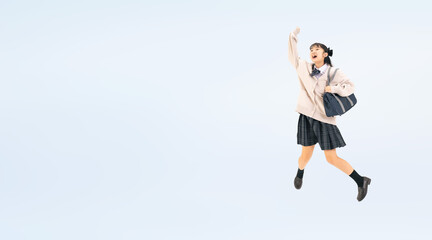 元気にジャンプする制服を着た女子学生の全身写真