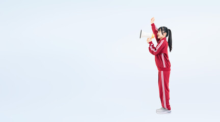 拡声器で応援する体育ジャージを着た女子学生の全身写真