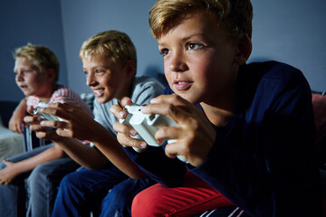 Gaming, friends and teens on sofa in home for playing, competition and online entertainment. Challenge, living room and boys with controller for video games, esports and winning on weekend together