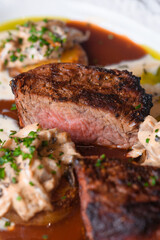 Pepper steak grilled with potatoes, mushroom julienne and three sauces