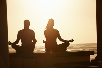 Meditation, space and sunset with couple on beach together for balance or mindfulness routine. Awareness, fitness and flare with calm people outdoor on coast for holistic health or lotus pose