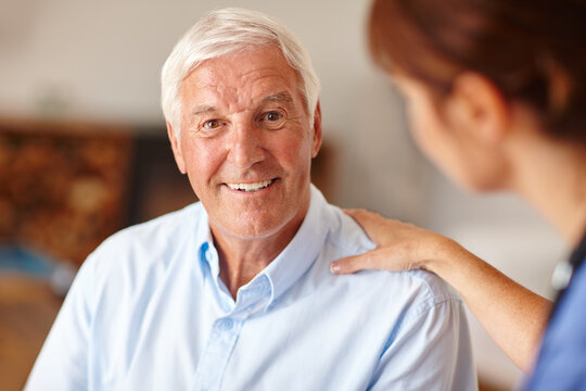 Caregiver, support or happy elderly man in home for portrait, trust or empathy with woman. Nurse, shoulder touch or senior person with comfort, medical healthcare or smile with kindness in retirement