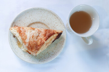 puff pastry , tart or pie with pineapple sauce stuffed and hot tea