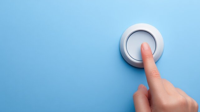 Hand presses button on blue wall surface hand activates blue wall mounted button for action