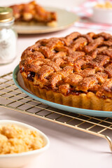 Homemade Apple Pie Slice on Pink Background with Cinnamon and Fresh Apples