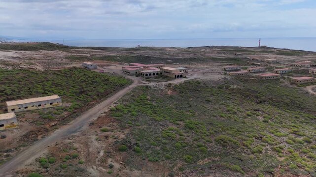 High altitude aerial shot over the desolate, sprawling main structure of the abandoned Sanatorio de Abades leper colony in Tenerife, Spain.