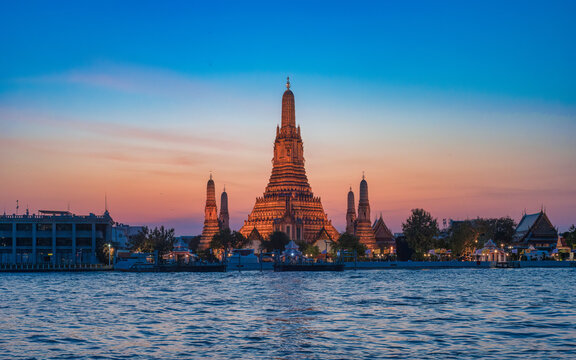 Sunset view of the Phra Prang of Wat Arun from Wat Pho pier in Bangkok, Thailand.