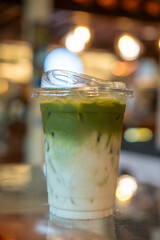 A cup of iced green tea latte, on the table