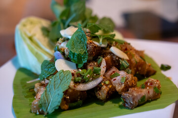Spicy crispy pork salad or Larb. Thai food, served on plate.
