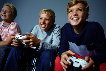 Video game, smile or siblings on couch with controller, competition or playful challenge in multiplayer. Low angle, children or family in house with tech, bonding or console match in virtual activity