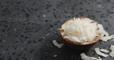 coconut chips in olive bowl on terrazzo surface