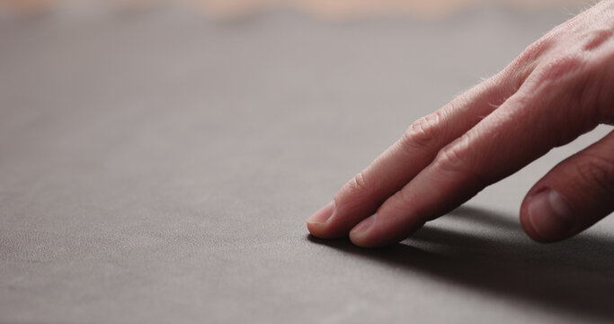 man hand checking brown leather piece closeup