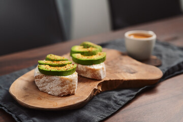 Avocado sandwiches with espresso for breakfast on walnut wood table