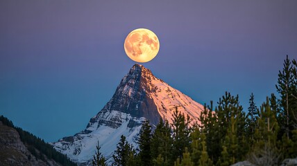 Full moon rising above snowy mountain peak at dusk in scenic landscape

