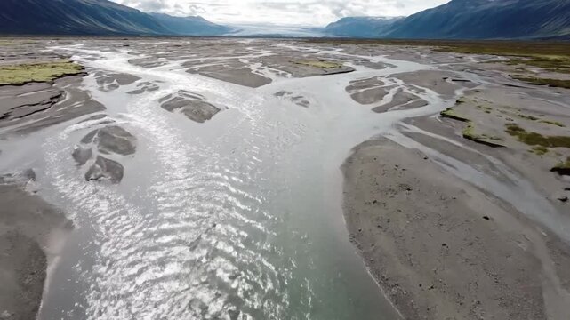 Intricate Waterway Networks: Capturing the mesmerizing, braided patterns of a glacial river as it carves its path through a vast, untouched landscape, showcasing the dynamic flow and sedimentation pro