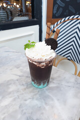 A refreshing chocolate drink topped with whipped cream and a cookie