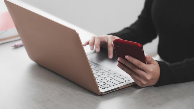 ノートパソコンとスマホを使って作業する女性