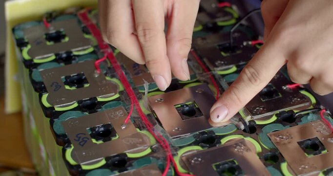 Spot welding nickel strips on a battery pack to improve electrical conductivity and durability.Adding a second nickel layer to reinforce the battery pack and enhance current flow.