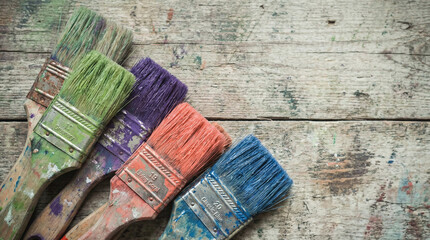 Colorful paint brush collection on weathered wood surface, artistic creation and DIY concept