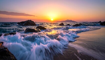 Sunset over a rocky beach. Waves crash onto the shore as the sun dips below the horizon