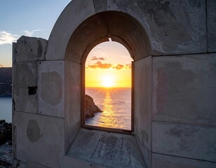 Sunset over ocean viewed through archway in stone structure
