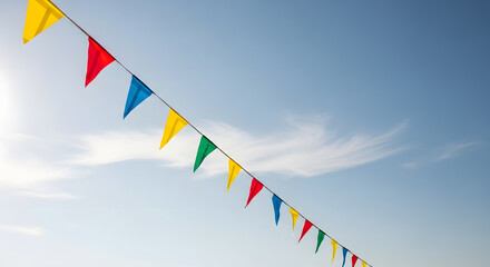 A festive string of colorful triangular pennant flags hanging against a bright blue sunny sky