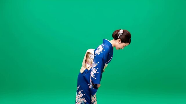 Woman in kimono bowing on green background for chromakey. Asian female in traditional attire making a respectful gesture.