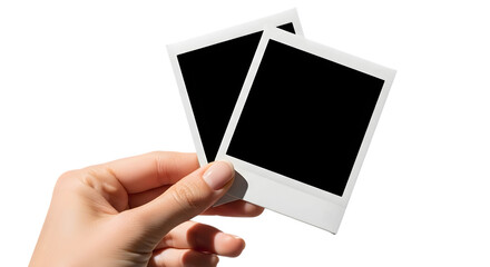 Hand holding two blank instant photo frames against a black background