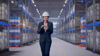 Front View of Asian Businesswoman Use Smartphone While Walking at Warehouse Aisle with Chemical or Oil Barrels on Pallet Racking - Powered by Adobe