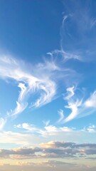 Vertical view of a blue sky with streaky white clouds