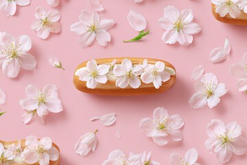 Delicate sweetness Eclair with fresh white flowers on pink background
