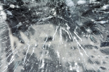 Intricate cracks and bubbles in frozen ice surface