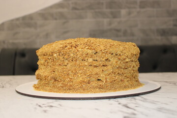 Delicious layered cake topped with crumbs displayed on a white board in a cozy setting
