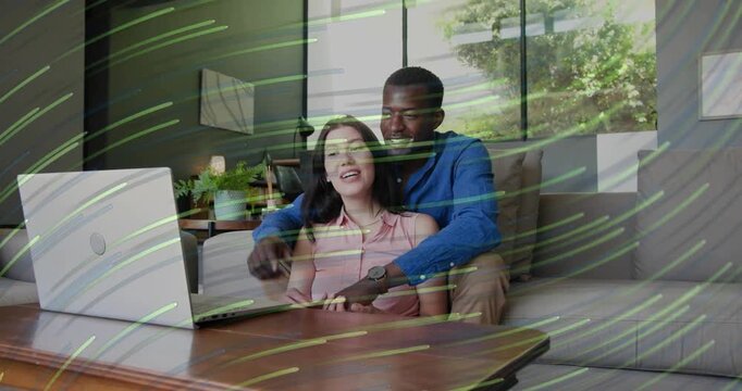 Couple hugging on couch, woman touching laptop taking call to greet, faint green overlay for tech