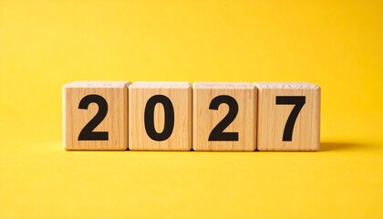 Wooden blocks displaying “2027” on vibrant yellow background with bold black numerals