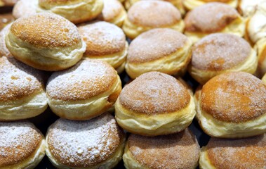 Delicious donuts sprinkled with powdered sugar offer a sweet treat, perfect for bakeries, cafes, and dessert promotions with a nostalgic touch