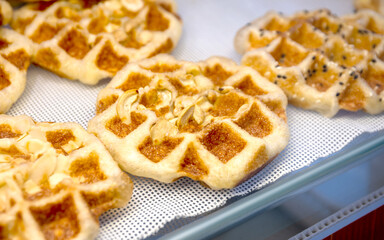 Waffle, Golden baked waffles on shelf, Waffle shop close-up, showcasing a crisp and appetizing texture. Perfect for food design, menus, and bakery advertising