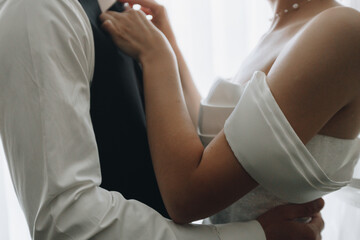 Obraz premium Bride adjusting groom’s tie