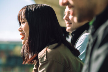 Side view of happy female spectator watching game from stadium stand on sunny day