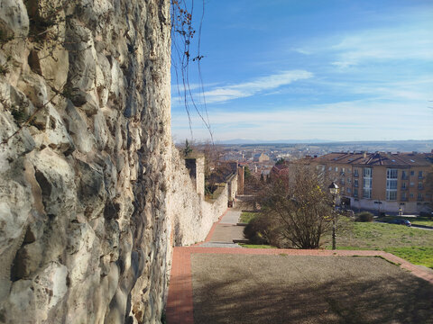 Muralla de piedra antigua bordeando el camino con vista panor&aacute;mica a la ciudad de Burgos